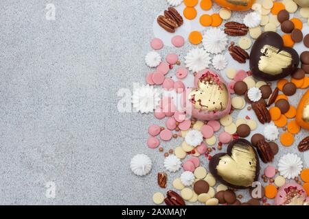 Assorted pink, orange, brown and green chocolate hearts with meringues, pecan nuts and chocolate drops Stock Photo