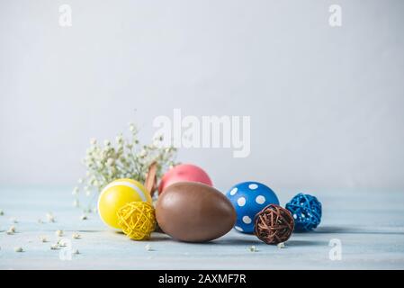 Bright colorful Easter eggs with spring flowers on a blue background. Festive spring Easter card. Stock Photo