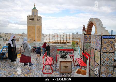 TUNIS, TUNISIA - DECEMBER 29 2019: Colorful tiled terrace overlooking the medina, with a view on the minaret of Ez Zitouna Mosque (Great Mosque) Stock Photo