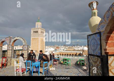 TUNIS, TUNISIA - DECEMBER 29 2019: Colorful tiled terrace overlooking the medina, with a view on the minaret of Ez Zitouna Mosque (Great Mosque) Stock Photo