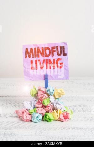 Writing note showing Mindful Living. Business concept for Having a sense of purpose and setting goals in life Reminder pile colored crumpled paper clo Stock Photo