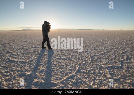 man photographing Irregular structures of salt at sunrise Stock Photo