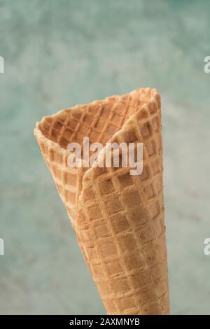 closeup of an empty ice cream cone over green background with copy space Stock Photo