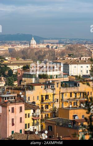 Views across Rome city with colourful old apartments in foreground, seen from Gianicolo or Janiculum Hill, Trastevere, Rome, Italy. Stock Photo