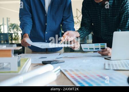 Image of engineer meeting for architectural project working with partner and engineering tools on workplace. Stock Photo