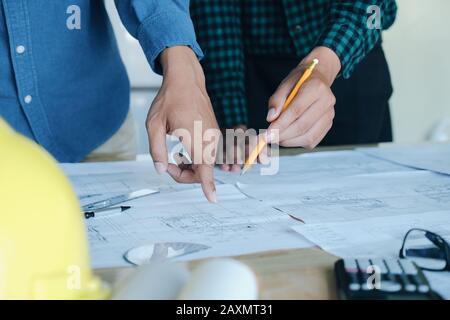 Image of engineer meeting for architectural project working with partner and engineering tools on workplace. Stock Photo