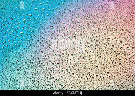 Water Drops on multi-colored rainbow Background. Stock Photo