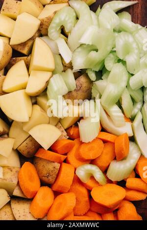 Chopped stew vegetables on a wooden cutting board Stock Photo