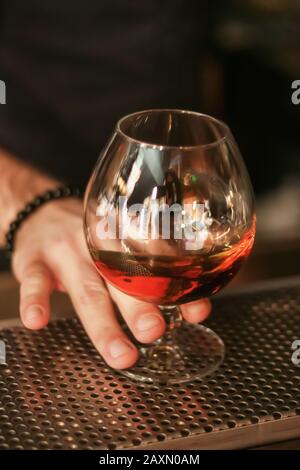 hand holding a glass of whiskey, alcoholic drink Stock Photo