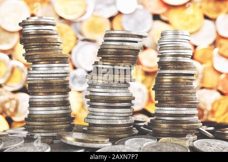 Wobbly towers made of diverse old coins, selective focus, color toning applied. Stock Photo
