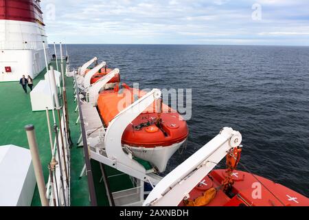 BALTIC SEA, SWEDEN - CIRCA JUN, 2018: Orange rescue lifeboats hang on both sides of vessel to rescue crew and passengers. It is cruise liner of Viking Stock Photo