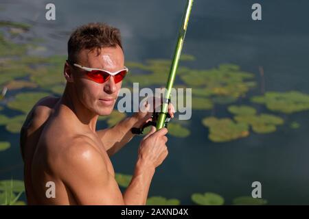 A beautiful man with a bare cake with a fishing rod Stock Photo - Alamy