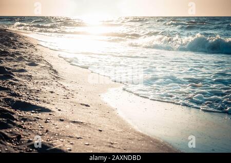 very beautiful reflection of the sun in the wet sand on the seashore, toned and filter Stock Photo