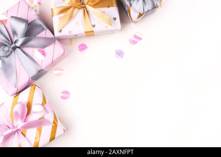 Several gift boxes with bows and confetti on a white background. Stock Photo