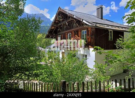 Upper Bavarian country house with floral decoration in the garden of castle Linderhof, parish of Ettal, Ammertal, Ammergauer alps, Upper Bavaria, Bava Stock Photo