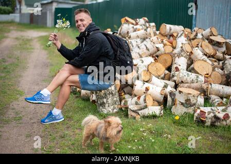 An urban man in the village, near a pile of firewood. Stock Photo