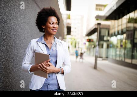 Urban happy business woman using tablet computer and working Stock Photo