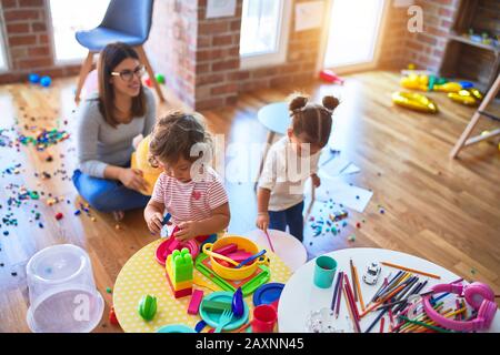 Young beautiful teacher and toddlers playing at kindergarten Stock Photo