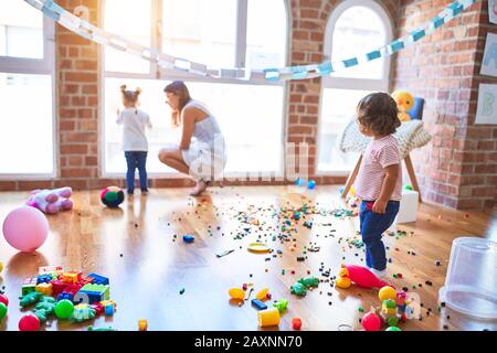 Young beautiful teacher and toddlers playing at kindergarten Stock Photo