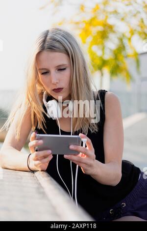Young woman in the skate park while the music hearing Stock Photo