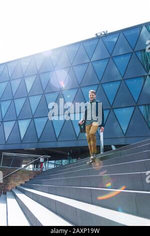 Businessman in front of modern office buildings, Frankfurt on the Main, Hessen, Germany Stock Photo