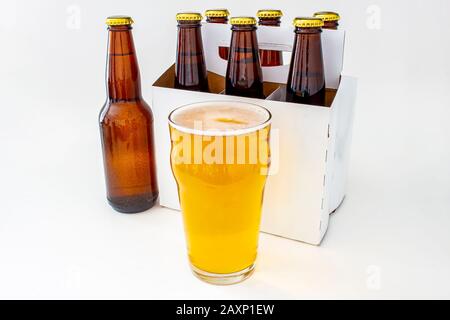 a Pilsner Style Lager brown bottle sic pack with a full pint of beer Stock Photo