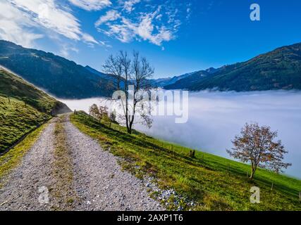 Sunny idyllic autumn alpine scene. Peaceful misty morning Alps mountain view from hiking path from Dorfgastein to Paarseen lakes, Land Salzburg, Austr Stock Photo