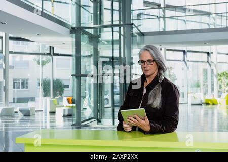 Businesswoman of middle age in the office, half portrait Stock Photo