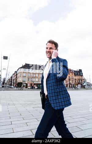 Businessman on the way to work with Smartphone, half profile Stock Photo