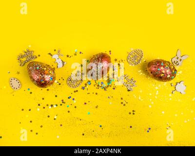 Easter wooden and with acrylic painted eggs against a yellow festive background, copy space Stock Photo