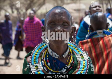 Older Masai woman dancing in traditional dress in Tanzania, Africa. Stock Photo