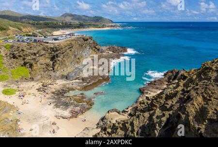 Tourists swim in Halona Beach Cove near the blowhole in Oahu, Hawaii Stock Photo