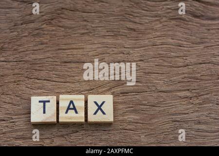 Tax with wooden alphabet blocks, on plank wooden background with copy space Stock Photo