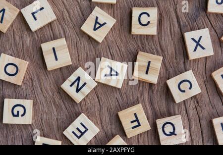 background of letterpress wood type printing blocks on wooden background, random letters of alphabet and punctuation stained by black inks Stock Photo