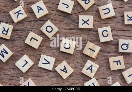 background of letterpress wood type printing blocks on wooden background, random letters of alphabet and punctuation stained by black inks Stock Photo