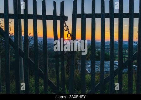 Beautiful sunset behind the wooden gate Stock Photo