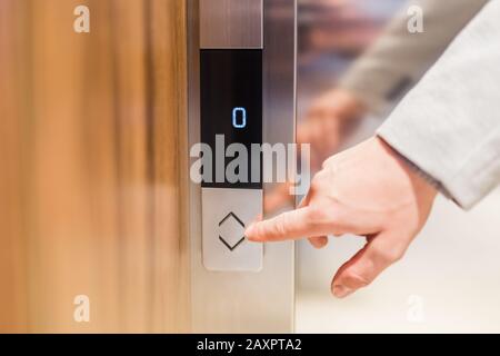 Close up of businessman hand pressing modern elevator button. Space for copy. Stock Photo