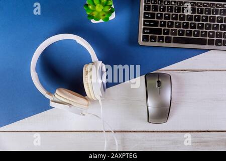 office computer keyboard lying on a white headphones with office work place Stock Photo