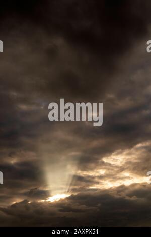 Dark storm clouds, broken by rays of light Stock Photo