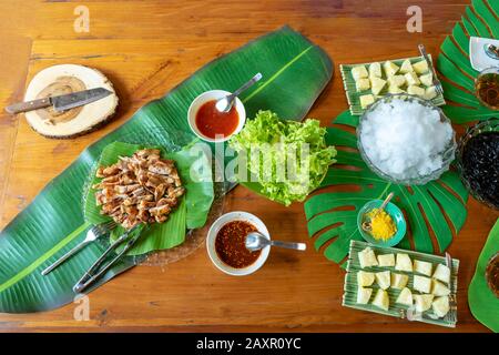 Mixed dessert in high tea break pineapple bread cream and ice black jelly with syrup on decoration leaf on wood table. Stock Photo