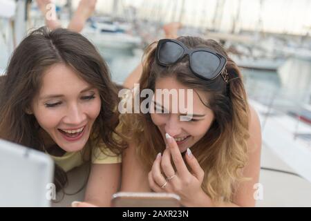 Happy joyful female friends enjoying talks and having fun online Stock Photo