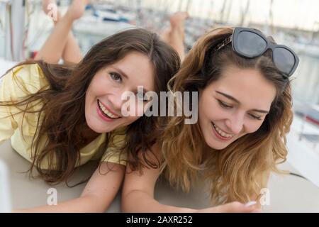 Happy joyful female friends enjoying talks and having fun online Stock Photo