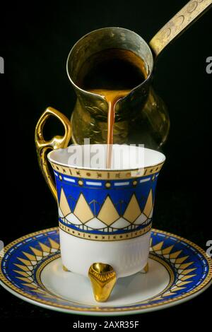 person pouring coffee from turka into a coffee cup Stock Photo - Alamy