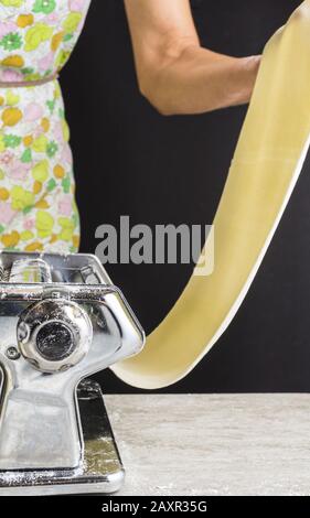 Woman stretching pasta dough. Stock Photo
