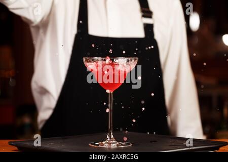 Barman in making cocktail at a nightclub. Nightlife concept. No face. Pouring into glass.. Horizontal Stock Photo