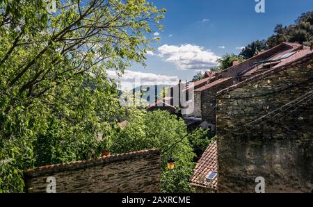 Village near Roquebrun. The hamlet is built directly on the black slate of the mountain. The houses are made out of the same material. Located in the Stock Photo