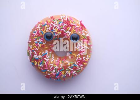 closeup of donut with funny face on white background  Stock Photo
