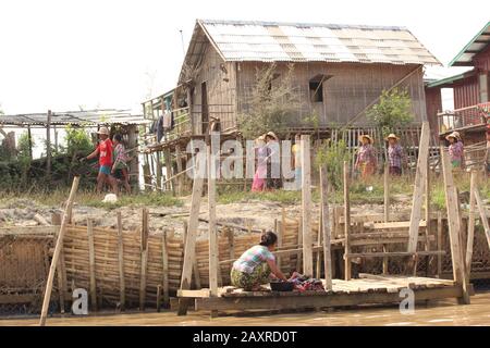 Burmese woman wash clothes at Inle Lake Stock Photo