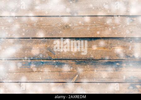 Winter background - top view of dark wooden rustic background covered with snow. Stock Photo