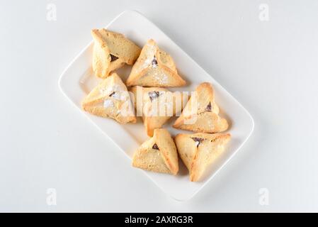 Purim holiday celebration. Hamantaschen cookies on white dish. Top view. Stock Photo